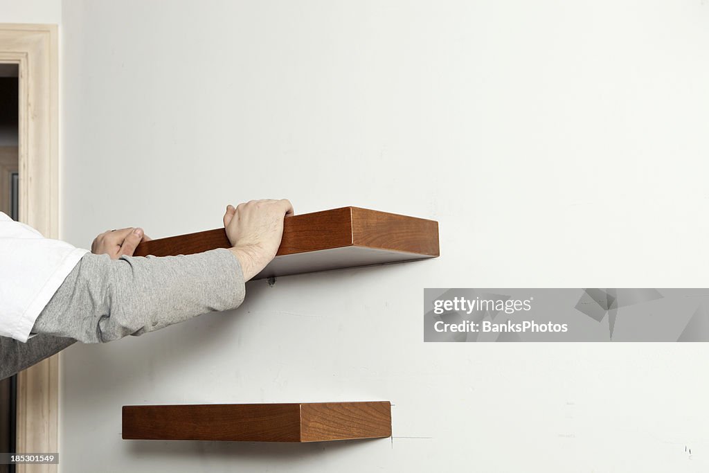 Worker Installing Cherry Wall Shelf at Remodeling Project