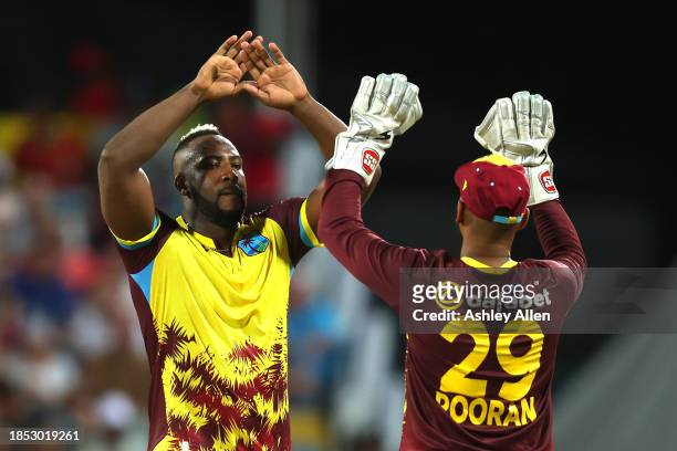 Andre Russell and Nicholas Pooran of West Indies celebrate the wicket of Liam Livingstone of England during the 1st T20 International between West...