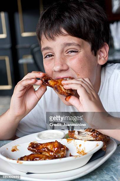 child having buffalo wings - chicken fingers stockfoto's en -beelden