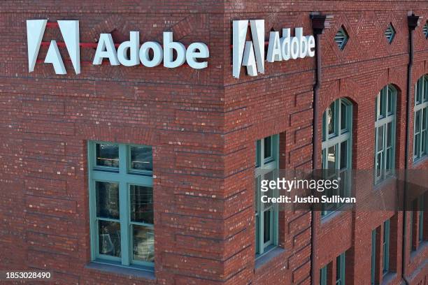 Sign is displayed on the exterior of an Adobe office on December 13, 2023 in San Francisco, California. Computer software company Adobe will report...
