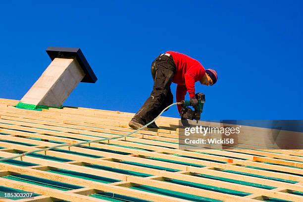 carpenter on a roof - isolatiemateriaal stockfoto's en -beelden