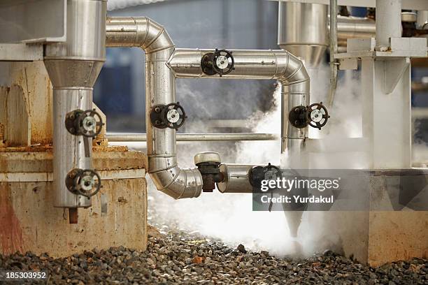 pipelines emitting steam at industrial site - steam stock pictures, royalty-free photos & images