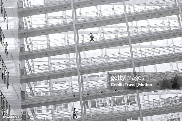 two business woman walking on elevated walkway - elevated walkway stock pictures, royalty-free photos & images