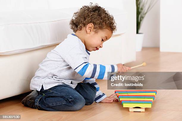 nahaufnahme von kleinkind spielt mit xylophon im wohnzimmer - xylophone stock-fotos und bilder