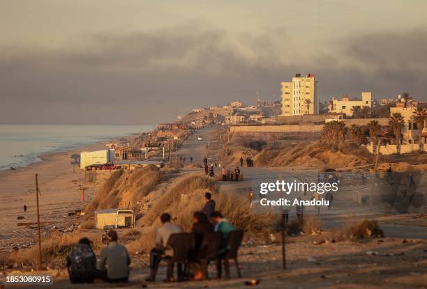 Palestinians spend time on a beach during sunset as people try to continue their daily lives under Israeli attacks in Deir Al-Balah, Gaza on December...