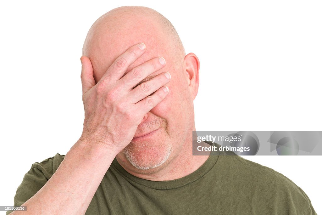 Homem triste a cobrir o rosto com a mão