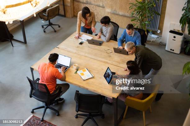 high angle view of multi-ethnic group of coworkers working in a co-working space - founder stock pictures, royalty-free photos & images