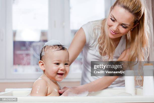 mother and baby bath - mother and baby taking a bath stock pictures, royalty-free photos & images