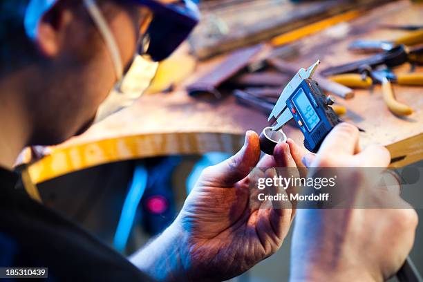 jeweller measuring a ring - fithaak stockfoto's en -beelden