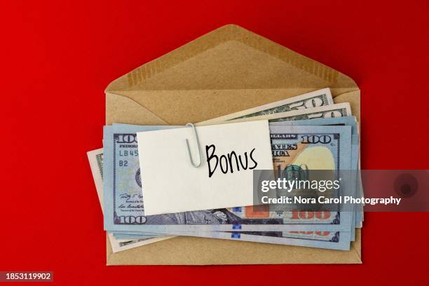 paper currency and brown envelope with text bonus on paper note - bonus pay stock pictures, royalty-free photos & images