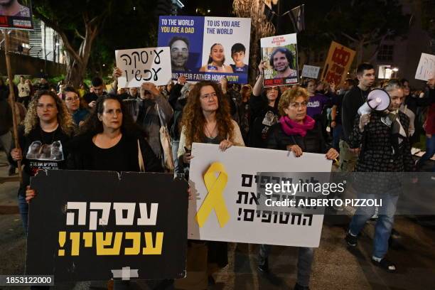 Friends and relatives of Israeli hostages held in Gaza since the October 7 attack lift placards during a demonstration in Tel Aviv on December 16,...
