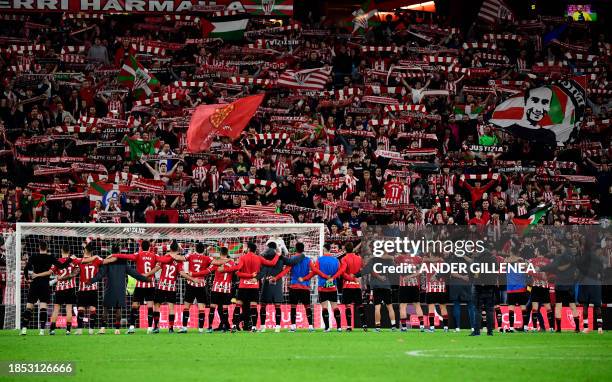 Athletic Bilbao players celebrate their win with fans on the stands at the end of the Spanish league football match between Athletic Club Bilbao and...