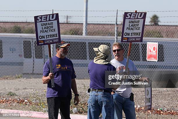 Bay Area Rapid Transit workers hold signs as they picket outside of a BART maintenance facility on the first day of the BART strike on October 18,...