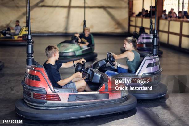 teenagers having fun riding bumper cars - toy car crash stock pictures, royalty-free photos & images