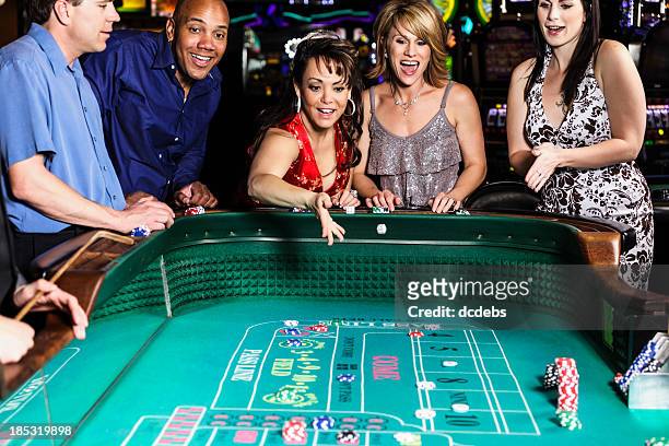 diverse group of people playing craps in casino - casino dealer stockfoto's en -beelden
