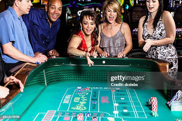 diverse group of people playing craps in casino - casino dealer stock pictures, royalty-free photos & images