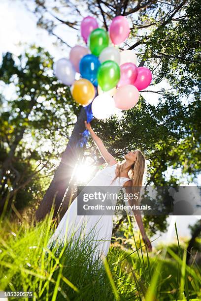 Young Woman With Balloons In Garden, Stockfoto