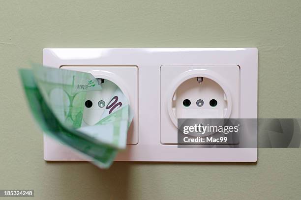 money in power outlet - saving electricity stock pictures, royalty-free photos & images