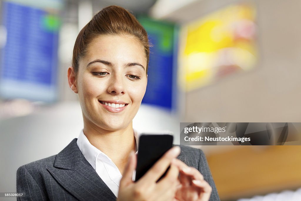 Business Woman Reading Text Message On Phone at Airport