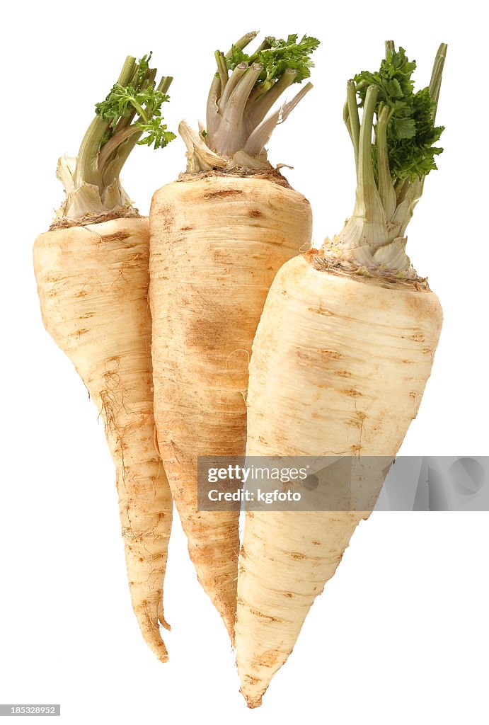 Three parsnips in front of white background