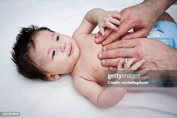 father giving a baby boy a massage - massage boy bildbanksfoton och bilder