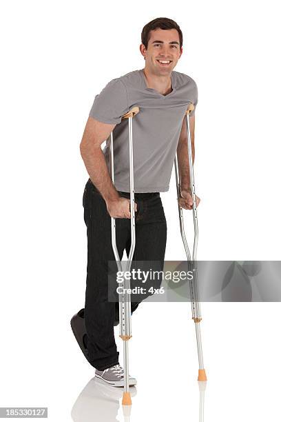 injured man walking with the help of crutches - injured leg stock pictures, royalty-free photos & images