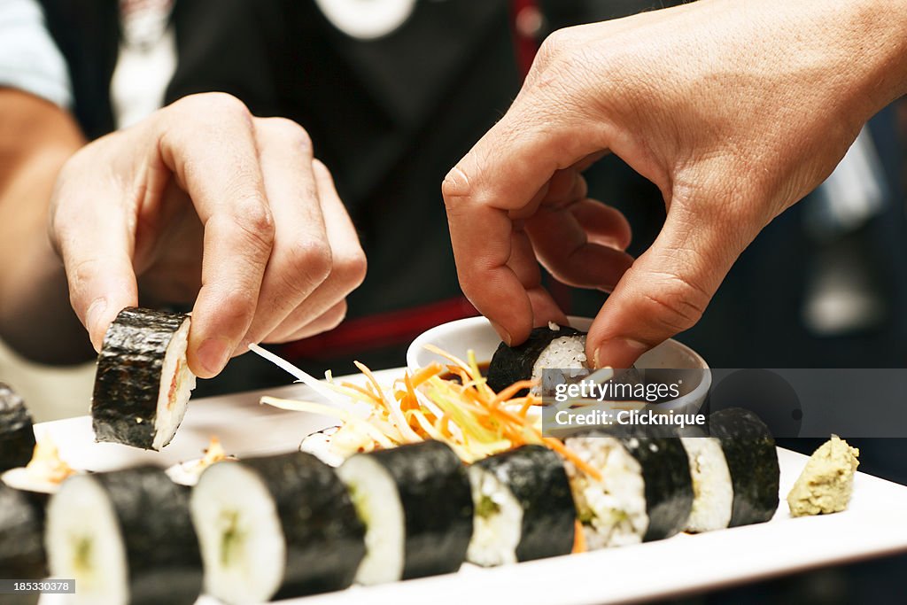 Hände in eine sushi-Platte im restaurant "Asian"