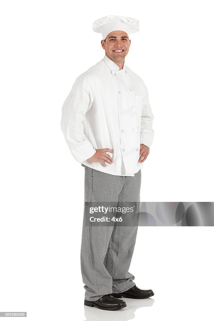 Happy male chef standing with arms akimbo