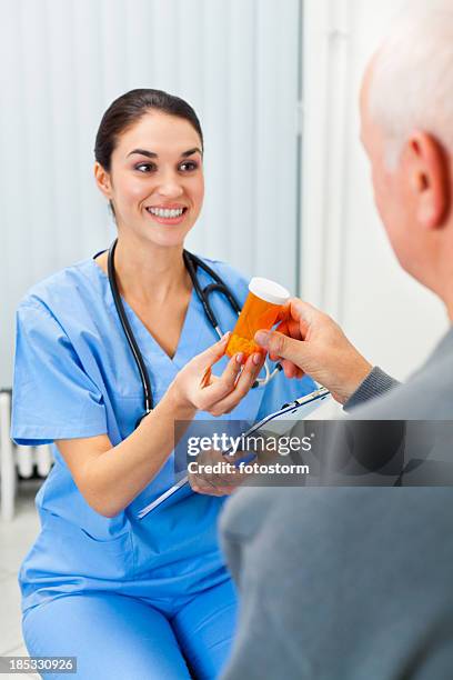 doctor giving pills to senior male patient - elderly receiving paperwork stock pictures, royalty-free photos & images