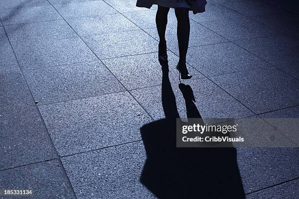 leg view of a woman in heels walking at night with shadow - dark street stock pictures, royalty-free photos & images