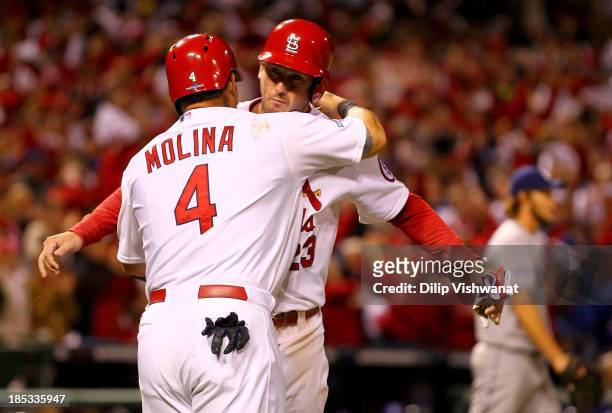 Yadier Molina and David Freese of the St. Louis Cardinals celebrate after both scoring in the third inning against the Los Angeles Dodgers in Game...