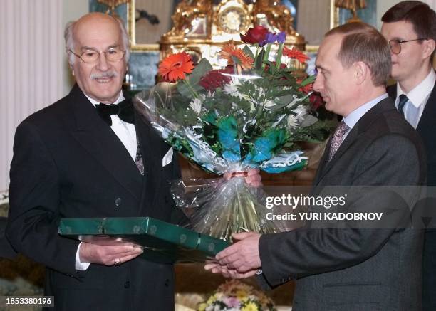 Acting Russian President Vladimir Putin hands flowers and a birthday gift to Russian actor Vladimir Zeldin 10 February 2000 while congratulating him...