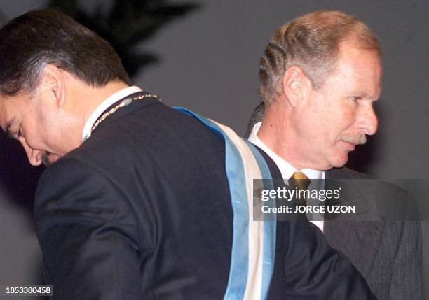 New Guatemalan President Alfonso Portillo stands before his predecessor Alvaro Arzu during inauguration ceremonies 14 January 2000. El recien electo...