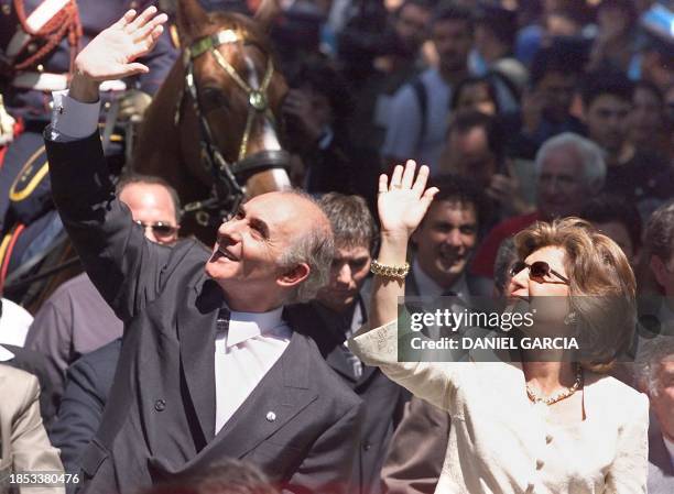 Argentine President-elect Fernando de la Rua and his wife Ines Pertine wave to wellwishers 10 December 1999 as they ride on a motorcade heading for...