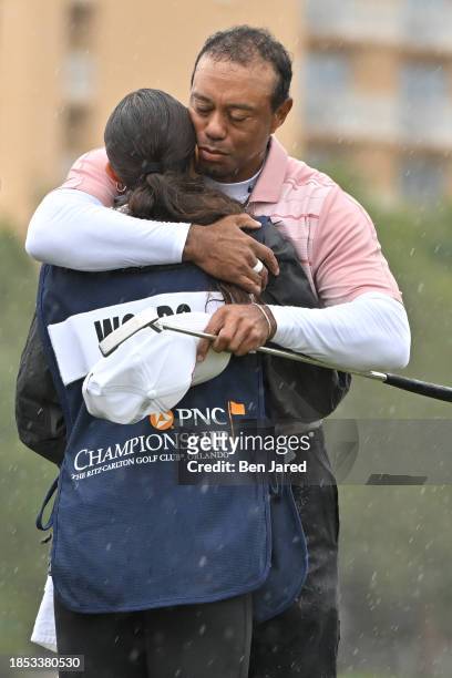 Tiger Woods hugs his daughter and caddie, Sam Woods, on the 18th green during the first round of the PNC Championship at Ritz-Carlton Golf Club on...