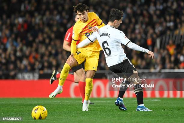 Barcelona's Portuguese forward Joao Felix fights for the ball with Valencia's Spanish midfielder Hugo Guillamon during the Spanish league football...