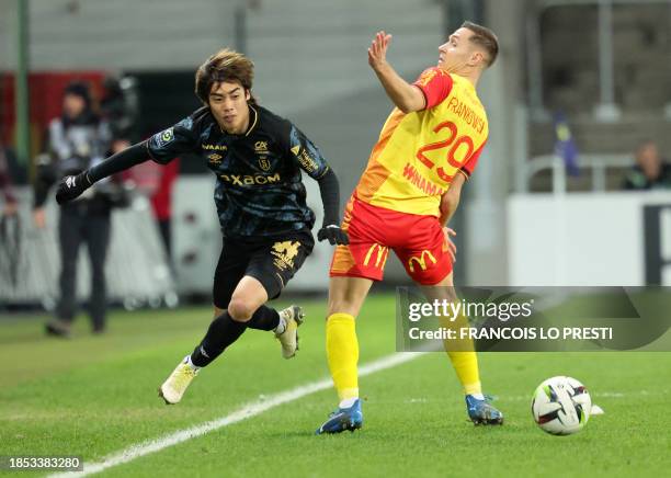 Lens' Polish defender Przemyslaw Frankowski and Reims' Japanese forward Junya Ito fight for the ball during the French L1 football match between RC...