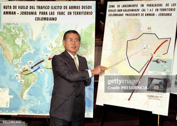 Peruvian President Alberto Fujimori points toward a map 21 August 2000 in Lima as he announces his government has broken up a ring shipping arms from...