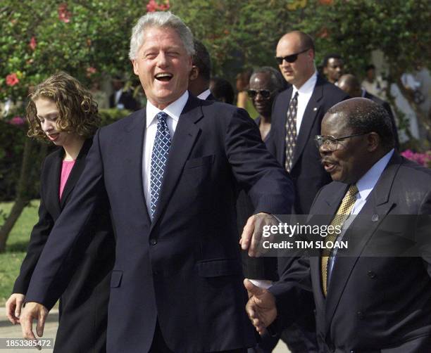 President Bill Clinton and daughter Chelsea walks with Tanzanian President Benjamin Mkapa after arriving at Kilimanjaro Airport 28 August, 2000 in...