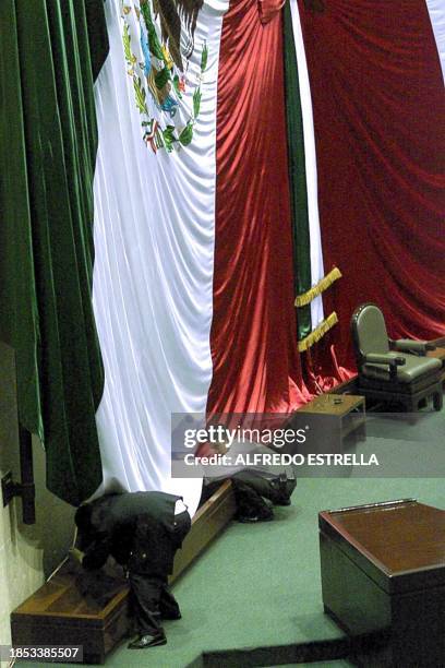 Security personnel check and fix the banner before the arrival of Mexican President Ernesto Zedillo, 01 September 2000. AFP PHOTO/Alfredo ESTRELLA...