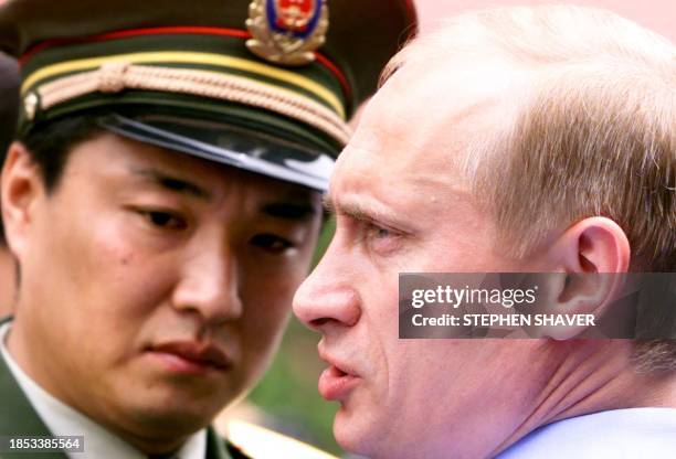 Russian President Vladimir Putin is escorted to his car by a Chinese military attache after touring Beijing's Forbidden City, 19 July 2000. Jiang and...