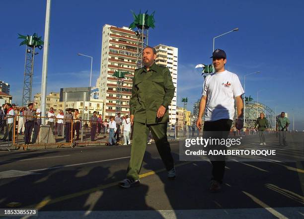 Cuban President Fidel Castro wears his usual uniform, for the march in Havana, 26 July 2000. To the right is Carlos Valenciaga, a personal assistant....