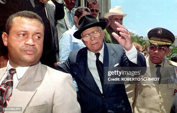 Dominican President Joaquin Balaguer waves to a crowd outside a voting station as he acknowledges cheers after casting his ballot in the country's...