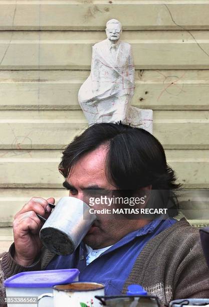 Worker drinks from a cup during the installation of the sculpture of former Chilean President Salvador Allende created by Chilean sculptor Arturo...