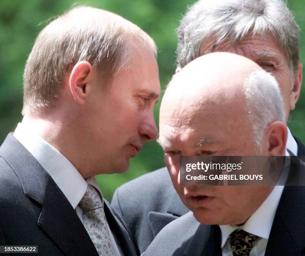 Russian President Vladimir Putin speaks to Moscow's Mayor Yuri Luzhkov after he unveiled a statue of Russian poet Alexander Pushkin in the Villa...