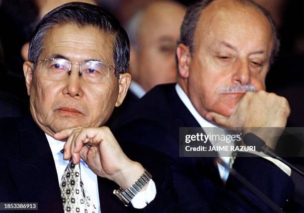 Peruvian President Alberto Fujimori listens, next to an advisor, to the speech of his Venezuelan counterpart Hugo Chavez during the closing of the...