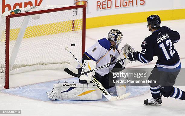 Olli Jokinen of the Winnipeg Jets scores the winning goal against Brian Elliott of the St. Louis Blues in shootout action of an NHL game at the MTS...