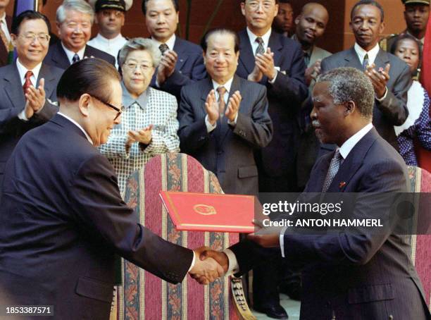 Chinese President Jiang Zemin and his South African counterpart Thabo Mbeki shake hands after signing a declaration of partnership between their two...