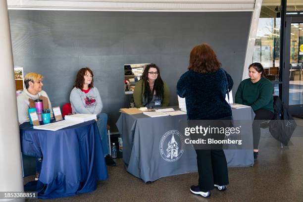 Visitor speaks with workers at a table during a Medicaid expansion informational event held by New Hanover County Department of Health and Human...