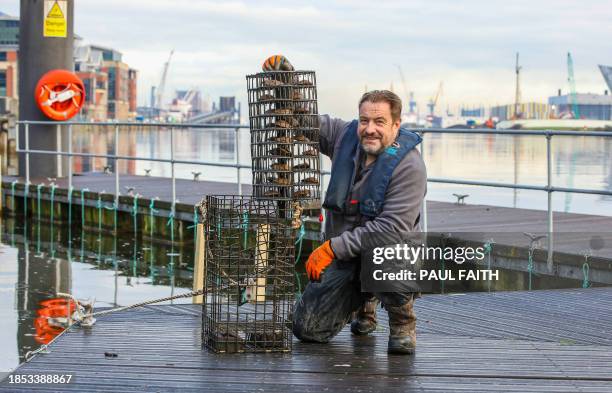 Conservation Manager with Ulster Wildlife David Smyth poses with an oyster cage at the City Quays, in Belfast, Northern Ireland, on November 28,...